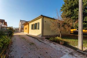 a small yellow building on the side of a street at Yourbanflat Ring River in Padova