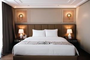 a bedroom with a large bed with two lamps at Radiant Hotel and Events in San Fernando