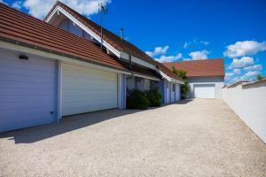 a row of garages in a house with a driveway at Gite de Mortagne, Villa avec Piscine in Gigny-sur-Saône