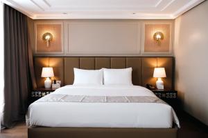 a bedroom with a large bed with two lamps at Radiant Hotel and Events in San Fernando