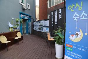 a patio with chairs and a sign on a building at EKonomy Hotel Incheon Bupyeong Branch in Incheon