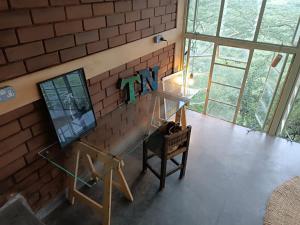 a room with a brick wall with a desk and a chair at Embibi Mindfulness Cabins in Ngong