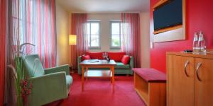 a hotel room with red walls and a table and chairs at Hotel Weisses Lamm in Veitshöchheim
