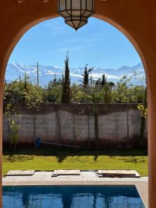 a view of a swimming pool through an archway at VILLA Les 3 Palmiers in Amezrou
