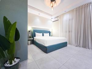 a bedroom with a bed and a potted plant at HOMETEL An Nahdah in Jeddah