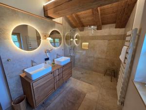 a bathroom with two sinks and two mirrors at Eberlehof in Riezlern +41 photos