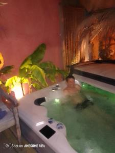 a man in a jacuzzi tub in a room at D'Ici ou D'ailleurs in Barneville-Carteret