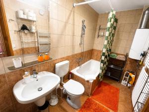 a bathroom with a sink and a toilet and a tub at NEVA apartman in Hévíz +34 photos