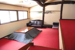 a room with a bed and a couch in a room at Ichinokurasou in Hakuba