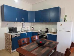 a kitchen with blue cabinets and a wooden table at Ippokratis 1 in Larisa +13 photos