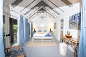 a bedroom with a bed in a room with blue curtains at Tiamo Resort in Congo Town +34 photos