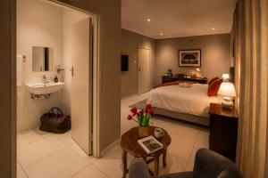 a bedroom with a bed and a bathroom with a sink at Kentucky Hotel in Harare