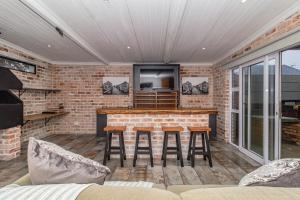 a living room with a bar with stools at Ruby on Hamilton in Windsor Park