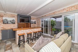 a living room with a couch and a bar at Ruby on Hamilton in Windsor Park