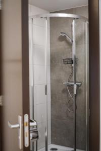 a shower with a glass door in a bathroom at Tiny's Herberg in Woerden +35 photos