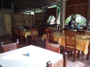 a dining room with tables and chairs and a person in the background at Centro Ecoturistico Ya´ajche in Lacanjá