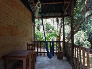 a porch of a wooden cabin with a swing at Centro Ecoturistico Ya´ajche in Lacanjá