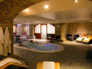 a hotel room with a hot tub with people in it at Mercure Moulins Centre Hôtel de Paris in Moulins