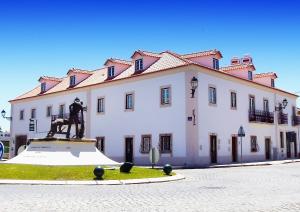 a large white building with a statue in front of it at Casa do Largo - Golegã - Turismo de Habitação in Golegã