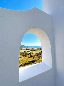 an archway in a white wall with a view at Marcos Beach in Mylopotas