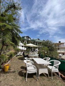 a group of tables and chairs in front of a building at Hotel Heaven and Hills in Kasauli