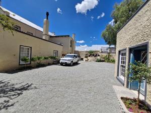 a white truck parked in a driveway next to a building at Coniston Villa in Colesberg