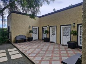 a building with doors and a patio with potted plants at Coniston Villa in Colesberg