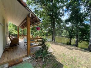 a porch of a house with a deck and a lake at Chalet Eden Insolite in Pionnat