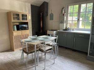 a kitchen with a table and chairs in a kitchen at Chalet Eden Insolite in Pionnat