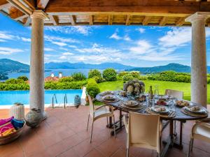 a table on a patio with a view of the water at Villa Marta in Meina