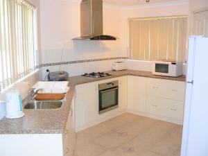 eine Küche mit einer Spüle und einer Mikrowelle in der Unterkunft Geraldton Luxury Vacation Home with free Streaming in Geraldton