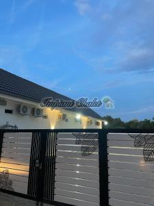 a fence with a gate in front of a building at Impiani Chalet with Private Pool in Kuala Terengganu