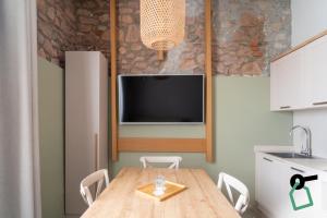 a kitchen with a wooden table with chairs and a tv at Hotiday Relais Costa degli Etruschi in Vada
