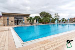 a large swimming pool in front of a building at Hotiday Relais Costa degli Etruschi in Vada