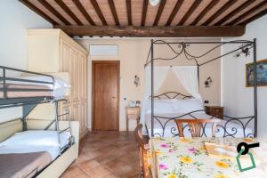 a bedroom with two bunk beds and a table at Hotiday Relais Costa degli Etruschi in Vada