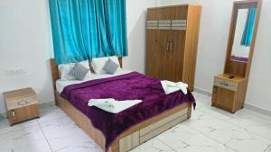 a bedroom with a bed with purple sheets and two towels at Blu Laguna Beach Homestay, Agatti Island, Lakshadweep - Only For Indian Nationals with valid entry permit in Agatti