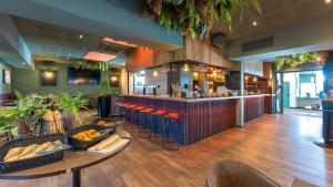 a bar in a restaurant with a counter and chairs at Campanile PRIME - Lyon Meyzieu Eurexpo Arena Stadium in Meyzieu