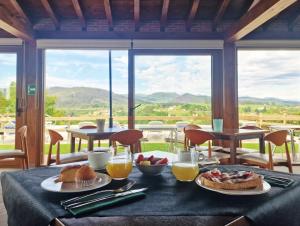 a table with two plates of food and orange juice at Hotel Verdemar by Grupo A Cobijo in Lamadrid