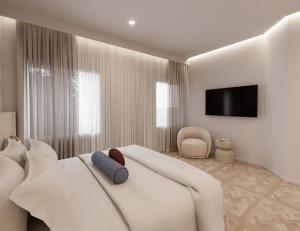 a bedroom with a white bed with a tv on the wall at The Character in Athens