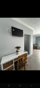 a living room with a tv on a white wall at Nightingale Guesthouse Randfontein in Randfontein
