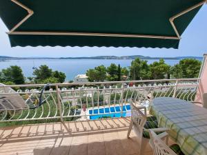 a balcony with a table and chairs and a view of the water at Apartments Žgogo in Trogir