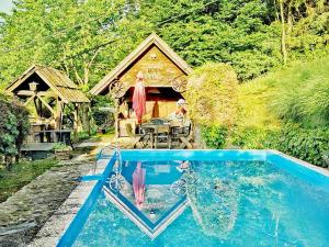 a house with a swimming pool in front of a house at Glamping MM in Muta