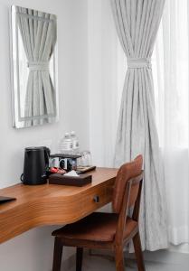 a wooden desk with a chair next to a window at GermanHomesHotel in Thimi