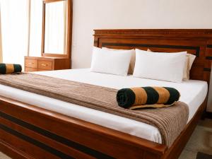 a bedroom with a large wooden bed with white pillows at RT Point Gombamiya Hotel Kandy in Huluganga +23 photos
