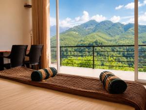 a room with a large window with a view of a mountain at RT Point Gombamiya Hotel Kandy in Huluganga