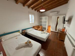 a hotel room with two beds and a couch at Casa Puerta Azul By Solymar Properties in Almáchar +27 photos