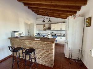 a kitchen with a brick counter and a refrigerator at Casa Puerta Azul By Solymar Properties in Almáchar