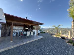 a patio with a table and chairs on top of a house at Casa Puerta Azul By Solymar Properties in Almáchar