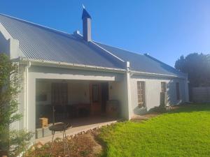 a white house with a patio and a yard at Kings Place Montagu in Montagu