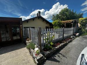 a white picket fence in front of a house at l'Orée des Moraines in Monnet-la-Ville